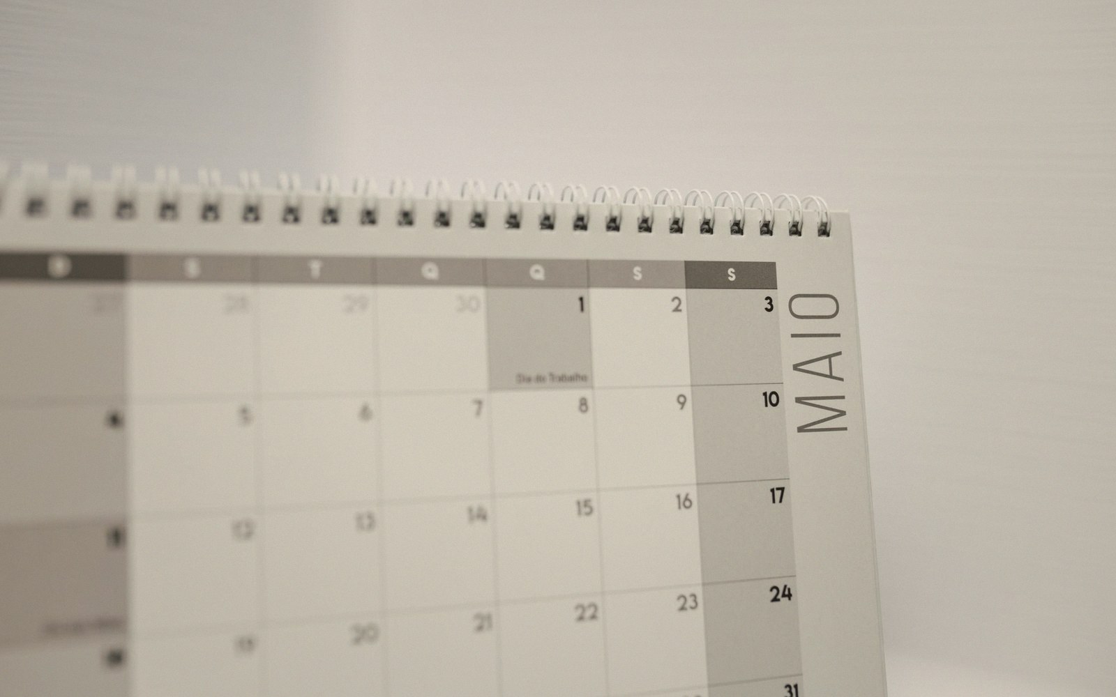 Close-up of a spiral-bound desk calendar showing the month of May